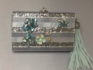Sparkly Gray Vintage Style Lucite Clutch With Hideaway Silver And Blue Cross-Body Chain; Adorned With Vintage Silver And Blue Enamel Flowers And Hummingbirds, Topped With Blue And Green Jeweled Clasp; Large Light Blue Suede Tassel. Dimensions - Height 5"; Length 7"; Depth 1.75"; Chain 26"