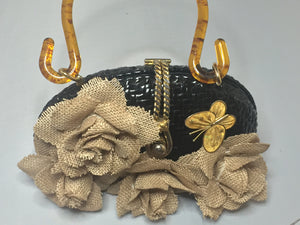 Vintage Shiny Black Straw Purse With Tan Burlap Hand-Made Flowers Adorned With Golden Bees And Butterflies With Unusually Shaped Translucent Tortoise Lucite Handle And Golden Rope Closure. Dimensions - Height 6.25"; Length 9"; Depth 2.5"; Handle 5.5"