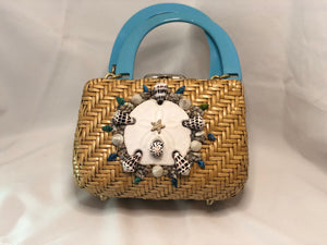 1960's Lewis Vintage Tan Natural Straw Purse, White Sand Dollar With Multi-Colored Shell Motif On Front. White Starfishes on Back. Blue/Tan Side Lining, Two Compartments With Tan French Trim. Golden Brass Hardware, Teal-Blue Lucite Handles. Dimensions - Height 7"; Length 8.5"; Depth 5"; Handle 5"