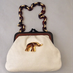 Vintage purse with supple vanilla leather which complements the bold browns and golds of the strolling elephants adorning it. A tortoise and golden chain handle and lucite frame are so classic, creamy and dreamy. Dimensions - 6" Height; 8" Width; 15" Length with chain