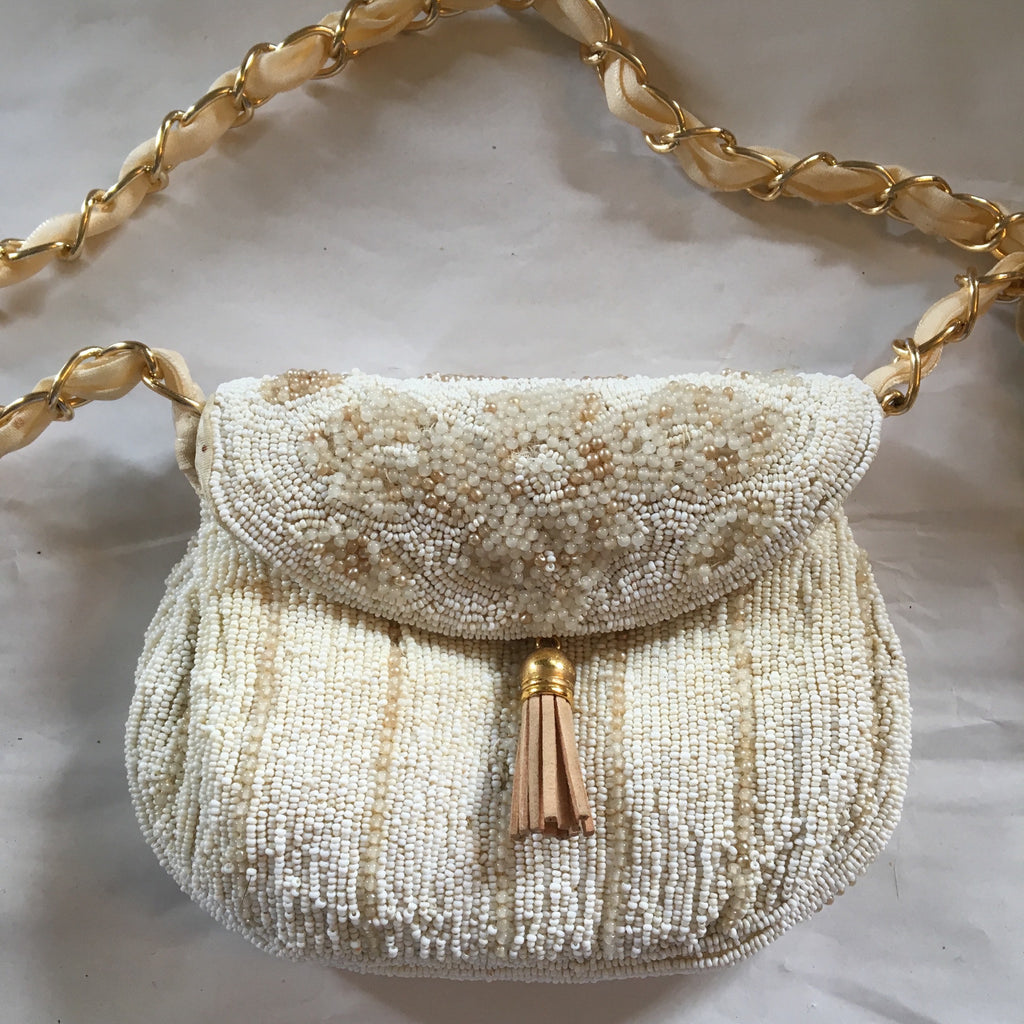 Vintage purse micro-beaded in shades of pearl, ivory and gold. Lined in faux ostrich skin, this bag is perfect for bride, bridesmaid, flower girl or mother of the bride.  Dimensions - Height 4"; Width 5 1/2"; Handle 12"; Depth 2"