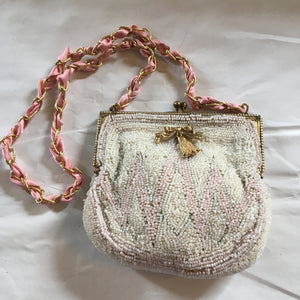 Incredible micro-beading in shades of beige and pink, this petite purse is a thing of perfection.  Dimensions - Height 3 1/2"; Width 4 1/2"; Handle 10"; Depth 2"