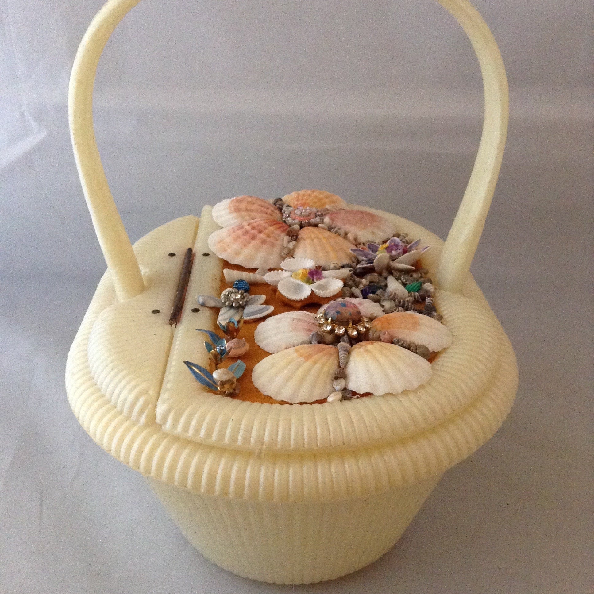 Vintage cream lucite basket purse with garden of seashells flowing the top. 