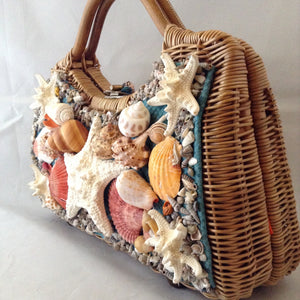 Lovely tan straw-grass purse made in Bali in the 1960s imagines a tropical sea bed with red silk lining. 1,014 shells, large and small, went into the making of this stunning piece. (Wanna count 'em?)  Dimensions - 8-1/2" Height; 13-1/2" Width"; 11 Length