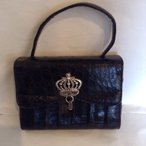 The Suzanne Bag returns, this time in genuine black alligator with a unique antique silver crown closure.  You'll feel like the princess you are.  From the 1960's in pristine condition, this is a bag to treasure forever.  Dimensions - Height 5 3/4"; Width 7 1/2"; Handle 4"; Depth 3"