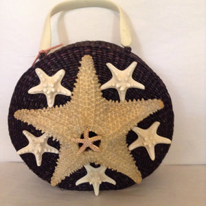 This unusual round black straw bag with lucite handle and starfish motif will be noticed everywhere.  Wear it with a simple black or white sundress and strappy sandals.  No other accessory needed!  Dimensions - Body 9-1/2"; Diameter 3-1/2"; Handle - 3 1/2"