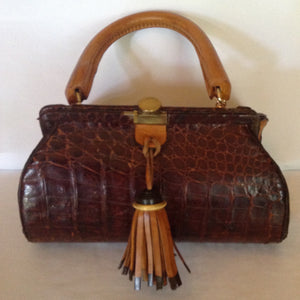 Original vintage brown crocodile purse with yellow leather handle, gussets and brown and black leather tassel make this vintage purse a true one-of-a-kind piece to carry everywhere.