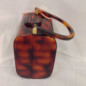 A classic tortoise-colored lucite vintage purse with an impressive enamel antique Maltese cross. As roomy as it is stately.  In perfect condition, and made to last a lifetime, of course.  American, circa 1940  Dimensions - Height 6 1/4"; Width 5"; Depth 4"; Handle 6"