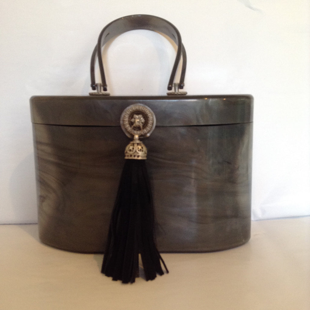 1940s Wilardy lucite purse in swirls of grey. Black suede tassel, vintage medallion closure, lined in luscious peacock green, original mirror. Very unusual shape; sophisticated and collectable.  Dimensions - Height 6"; Width 8"; Depth 5"; Handle 4"