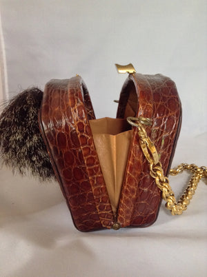 Beautiful brown South American vintage crocodile purse, a vintage Austrian hunting token, and a simple classic shape. The heavy chain detaches to be worn as a necklace or bracelet which looks and feels like 18K gold!  Dimensions - Height 5.5"; Length 7.5"; Width 3.5"; Chain 28"