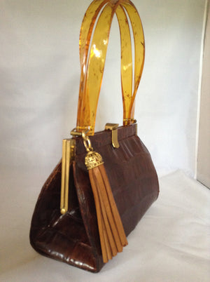 Vintage brown alligator purse with amber lucite handles, original hardware, soft leather lining and an amber tassel combine to make this classic Spanish beauty your go-to purse forever.  Dimensions - Height 6.5"; Width 9"; Depth 4"; Handle 7"