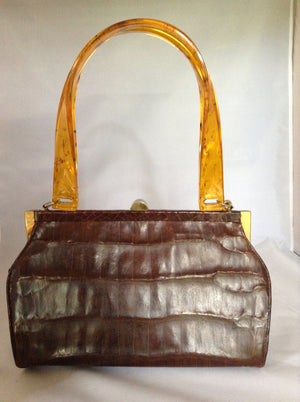 Vintage brown alligator purse with amber lucite handles, original hardware, soft leather lining and an amber tassel combine to make this classic Spanish beauty your go-to purse forever.  Dimensions - Height 6.5"; Width 9"; Depth 4"; Handle 7"