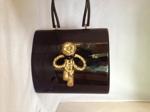 Classic black Wilardy lucite vintage purse from 1950s Miami adorned with a gold-leafed vintage bowknot.   You will have this in your wardrobe forever. So very Elizabeth Taylor!  Dimensions - Height 7.5"; Width 8.5"; Depth 5"; Handle 6"