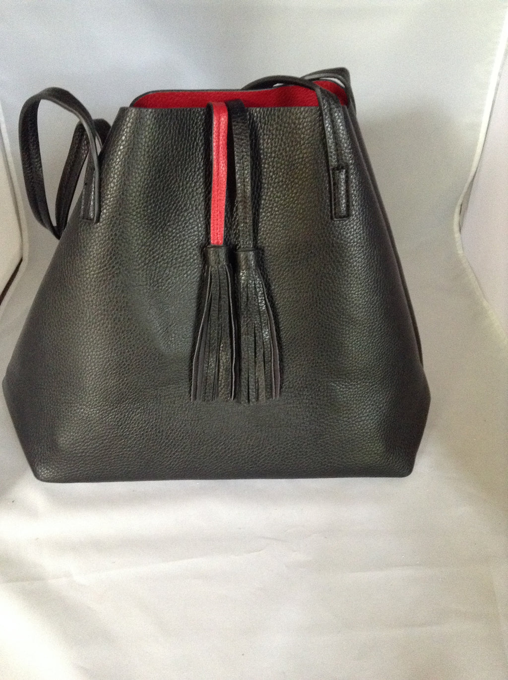 This English tote-style handbag is perfect for the world traveler since it reverses from practical black to fiery red and it even comes wit a matching clutch. How "veddy, veddy" British!   Dimensions - Height 13"; Length 12"; Depth 7"