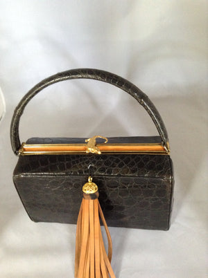 This magnificent vintage black alligator purse was made in Belgium in the 1950's for Saks and Bonwit Teller. The production was limited, so they are sought after by collectors. This example could retail for over $1000.00 (if you can find one.)  Dimensions - Height 9"; Length 7"; Depth 4"