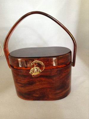 This vintage purse is the perfect marriage of a vintage tortoise carving poised au tremblant atop an oval 1950s lucite example by Wilardy. Antique amber and gold fob adorn the front. So classic, yet so today.  Dimensions - Height 6"; Length 4"; Depth 5"