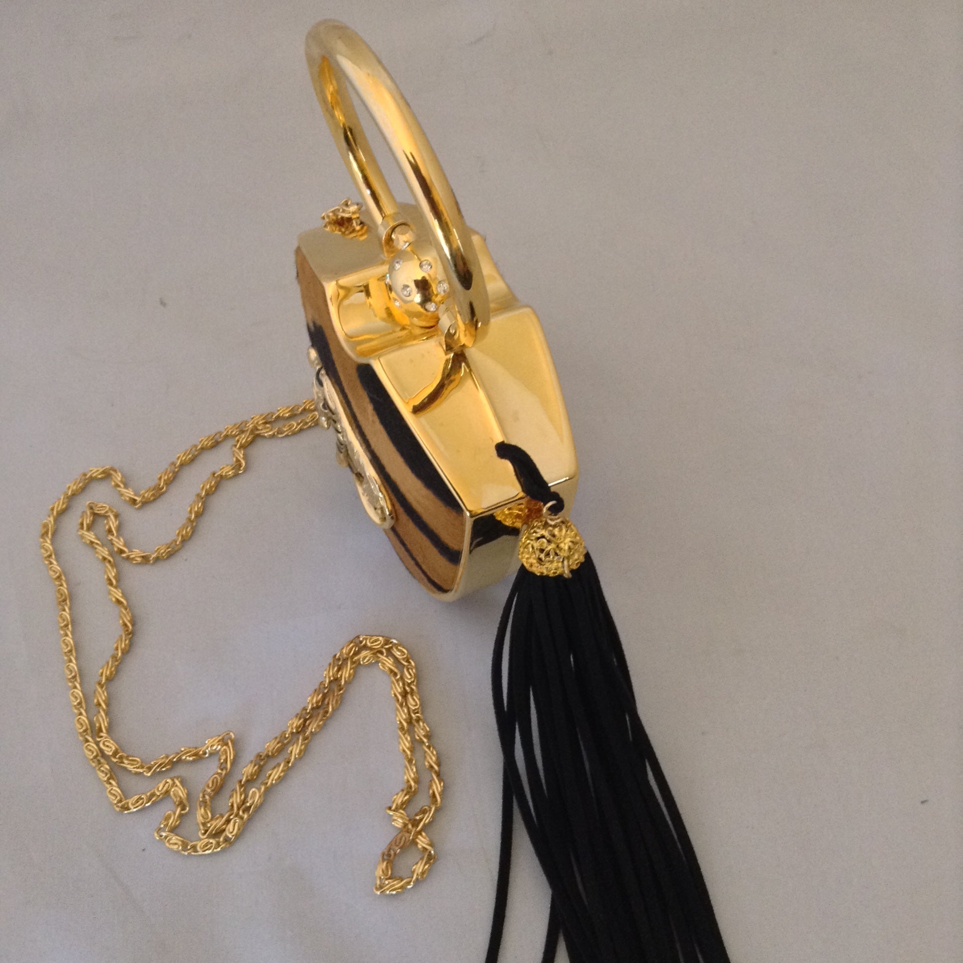 Darling yet daring, this vintage solid brass box purse roars attitude! Plush faux tiger pelt, golden tiger pendant, long black tassel, hideaway shoulder chain make it a conversation piece-de-resistance!