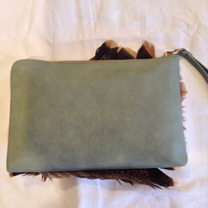 Iridescent turkey feathers and a mink pom-pom adorn this luscious teal vegan vintage leather clutch. With its inside zipper pocket & handy leather wrist strap it will even hold your notebook computer.  Dimensions - Height 9"; Width 11"; Depth 1" 