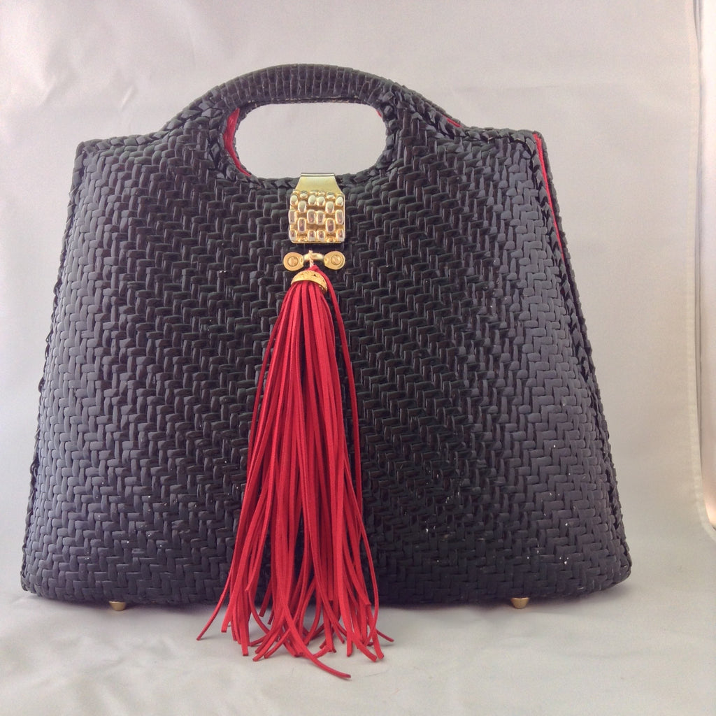 Super cool black straw vintage bag from Neiman Marcus. Red silk lining, over-sized suede tassel, wonderful hardware. Makes a statement. All you need is the right hat. A big one. Audrey would approve.  Dimensions - Height 14"; Width 14"; Depth 3"