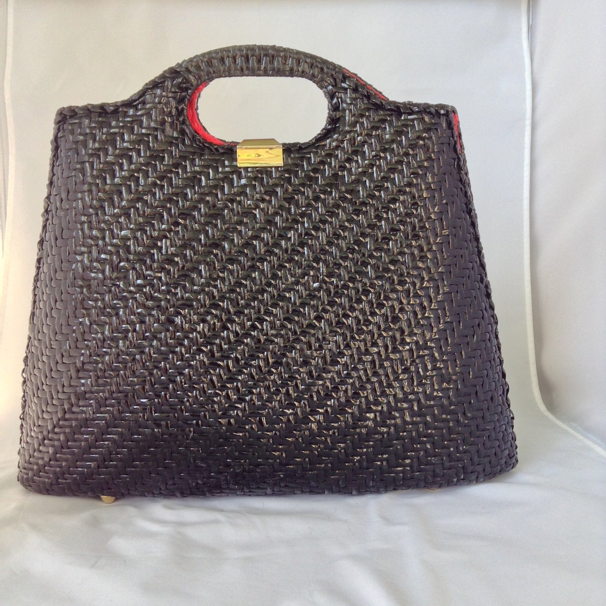 Super cool black straw vintage bag from Neiman Marcus. Red silk lining, over-sized suede tassel, wonderful hardware. Makes a statement. All you need is the right hat. A big one. Audrey would approve.  Dimensions - Height 14"; Width 14"; Depth 3"
