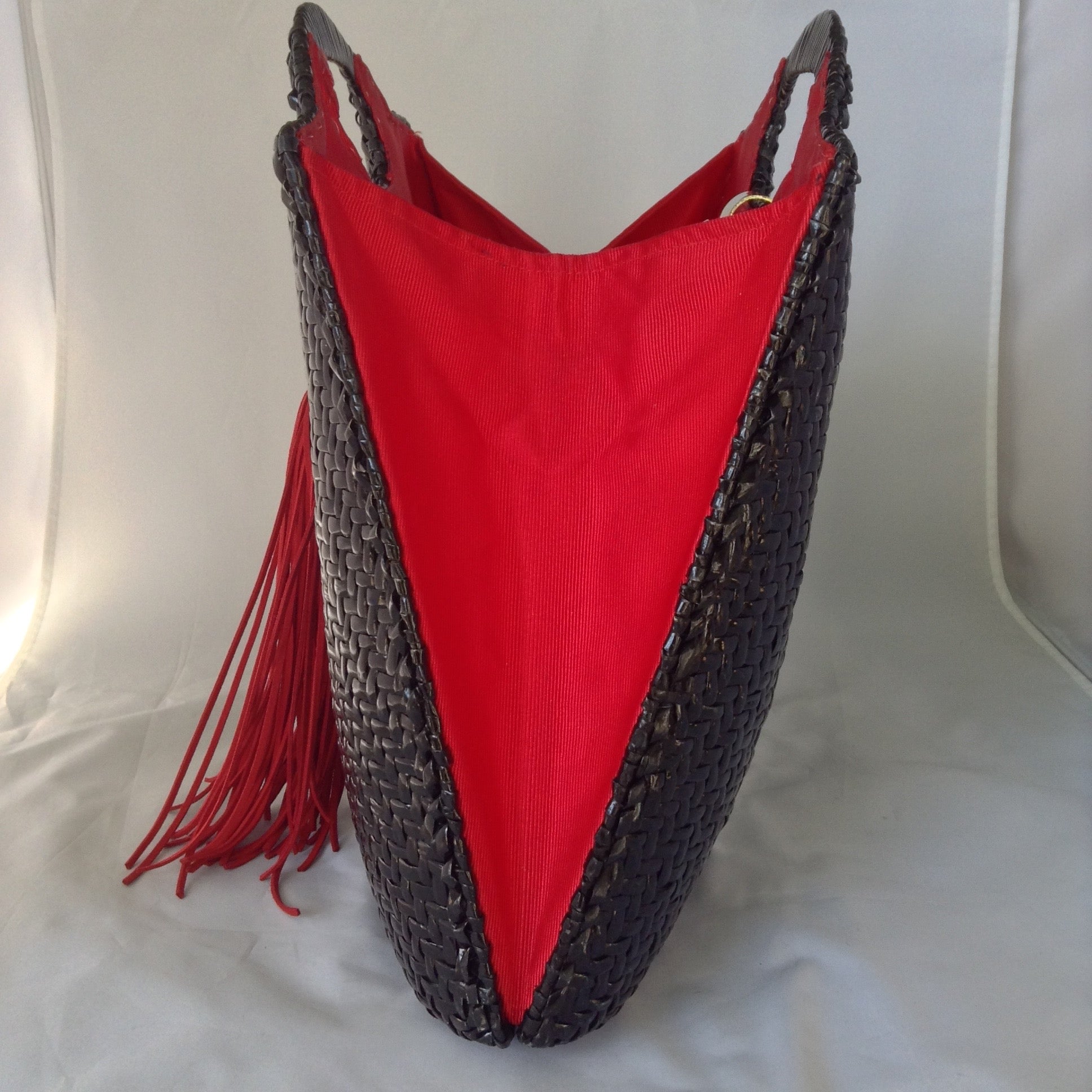 Super cool black straw vintage bag from Neiman Marcus. Red silk lining, over-sized suede tassel, wonderful hardware. Makes a statement. All you need is the right hat. A big one. Audrey would approve.  Dimensions - Height 14"; Width 14"; Depth 3"