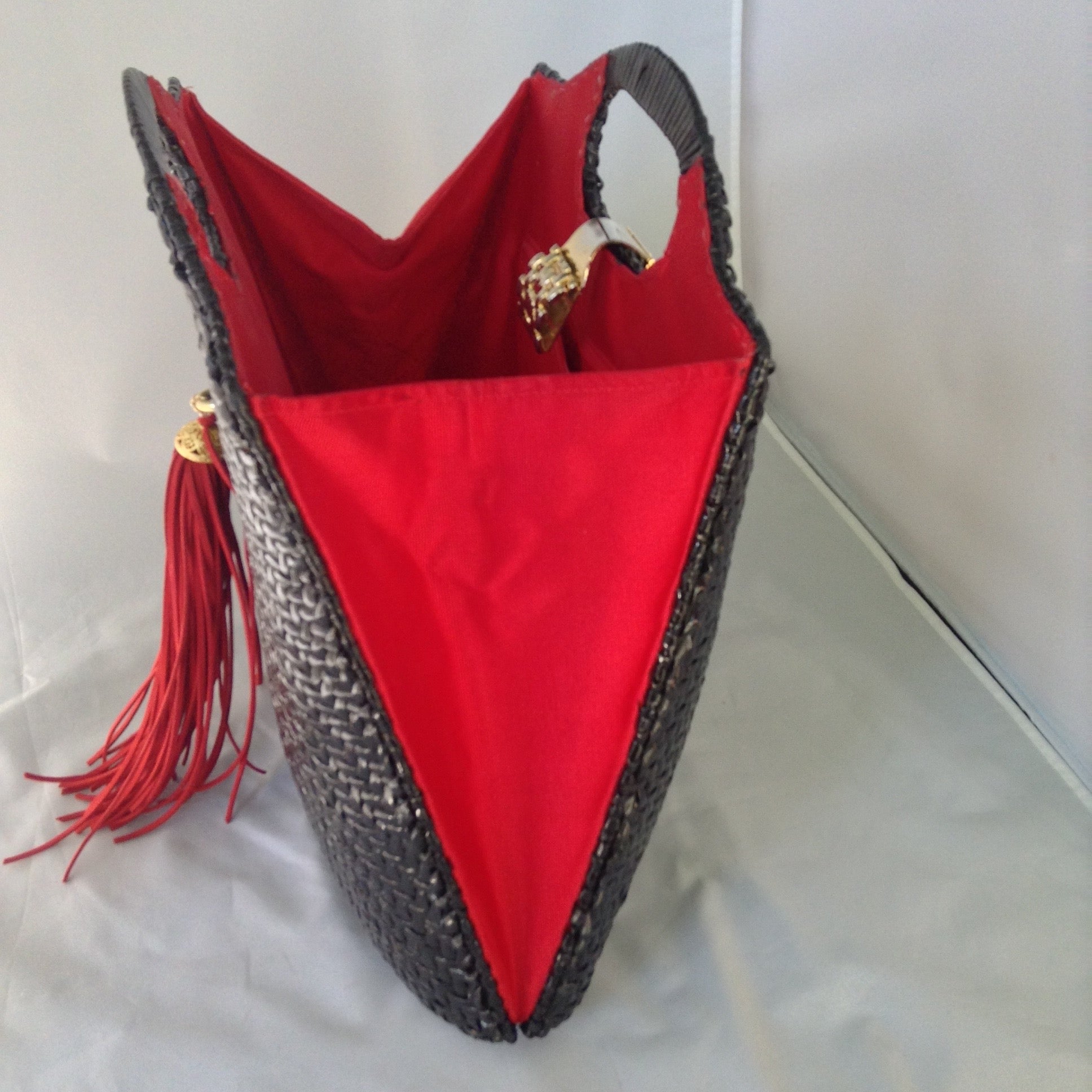 Super cool black straw vintage bag from Neiman Marcus. Red silk lining, over-sized suede tassel, wonderful hardware. Makes a statement. All you need is the right hat. A big one. Audrey would approve.  Dimensions - Height 14"; Width 14"; Depth 3"