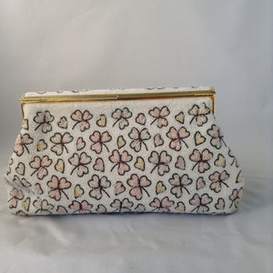 This vintage cream micro-beaded clover leaf clutch was made in France in the 1940s. It's covered with delicate light pink and green clovers and pink hearts too. Finally, it has a gold trim brass scalloped top that drapes over it's original vintage brass frame. They must not celebrate St. Patty in France because this gorgeous bag has never been used, but you'll carry it all Spring!  Dimensions - Height 5.5"; Length 9.5"; Depth 2"