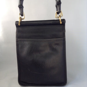 Formerly a staid and serious Coach mailbag, this supple black glove leather vintage purse becomes witty and charming with its enamel flower and new teal suede tassel and lining.  Dimensions - Height 9"; Width 7"; Depth 3"