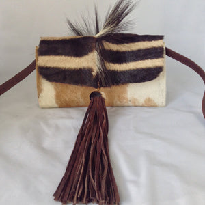 Cow plus zebra adds up to a fabulous cross-body/clutch with attitude! This adorable vintage purse is made from real cowhide and African zebra pelt with mane, suede lining, fabulous suede tassel, detachable leather cross-body strap. What more could a girl want?  Dimensions - Height 6"; Width 10"; Depth 2"