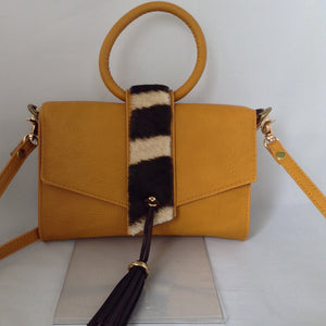 Charming "O" handle in vibrant mustard with accents of real zebra hide make for a darling vintage clutch. Add the detachable leather strap and voila - a cross-body charmer.  Dimensions - Height 6"; Width 8"; Depth 2"