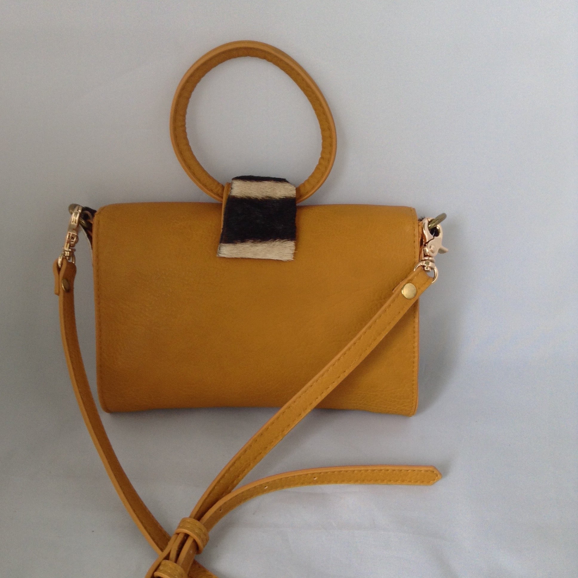 Charming "O" handle in vibrant mustard with accents of real zebra hide make for a darling vintage clutch. Add the detachable leather strap and voila - a cross-body charmer.  Dimensions - Height 6"; Width 8"; Depth 2"