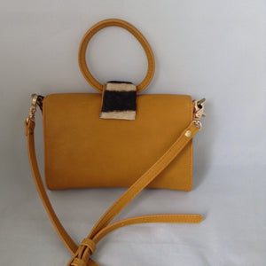 Charming "O" handle in vibrant mustard with accents of real zebra hide make for a darling vintage clutch. Add the detachable leather strap and voila - a cross-body charmer.  Dimensions - Height 6"; Width 8"; Depth 2"