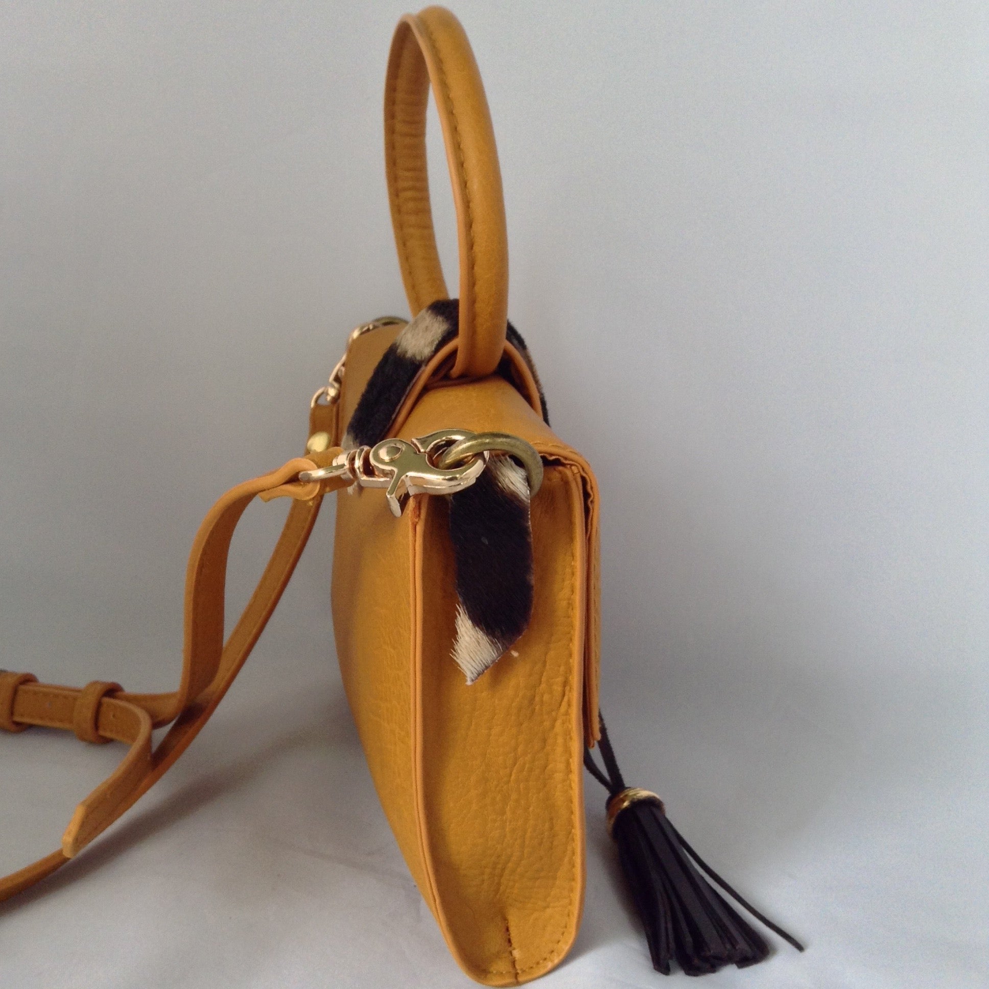 Charming "O" handle in vibrant mustard with accents of real zebra hide make for a darling vintage clutch. Add the detachable leather strap and voila - a cross-body charmer.  Dimensions - Height 6"; Width 8"; Depth 2"