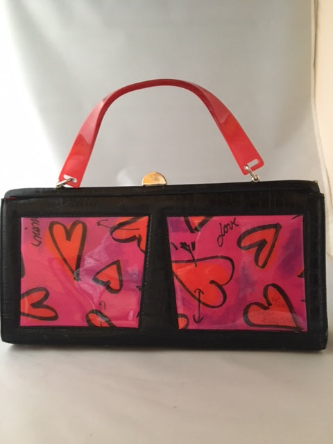 Darling rectangular 1980's vintage purse with hand-painted hearts and a happy cherub wielding arrows. Black satin and vintage lucite handles complete the look.  Dimensions - Height 7"; Width 13-1/2"; Depth 3"