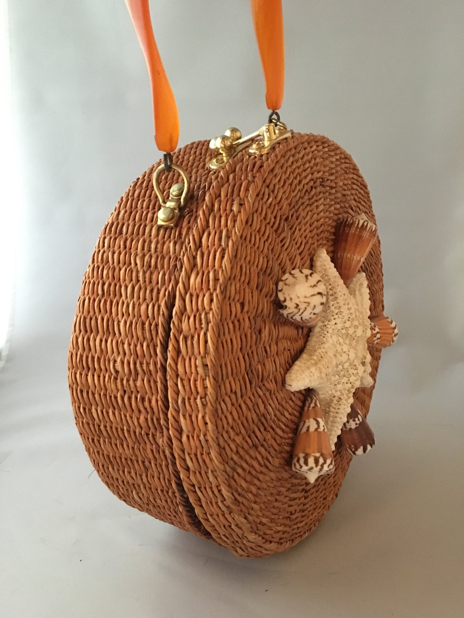 A great horned starfish and other wanna-bees encircle this unusual vintage straw bag. Leather lined with vintage lucite handle.You'll be in the inner circle wherever you take this!  Dimensions - Diameter 10"; Depth 4"; Handle 4"