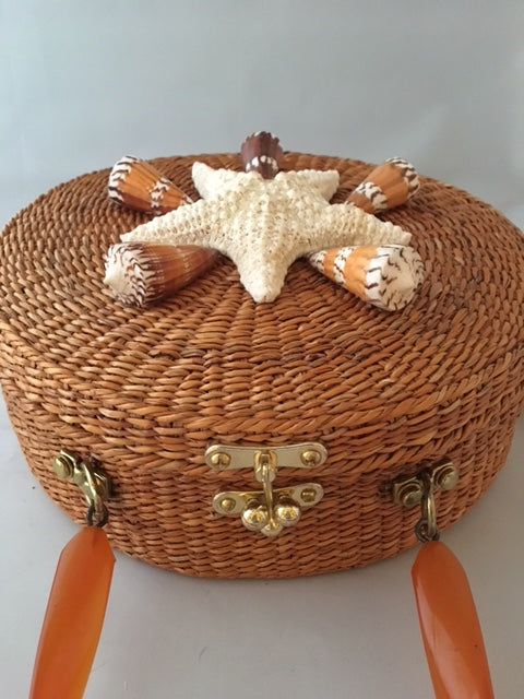 A great horned starfish and other wanna-bees encircle this unusual vintage straw bag. Leather lined with vintage lucite handle.You'll be in the inner circle wherever you take this!  Dimensions - Diameter 10"; Depth 4"; Handle 4"