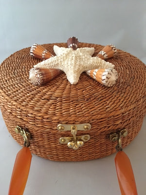 A great horned starfish and other wanna-bees encircle this unusual vintage straw bag. Leather lined with vintage lucite handle.You'll be in the inner circle wherever you take this!  Dimensions - Diameter 10"; Depth 4"; Handle 4"