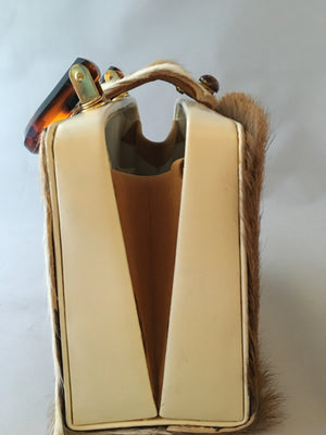 Would that be an Axis??? Square vintage handbag covered in baby deer pelt with an ostrich placket and tortoise buttons. What a combo!  Dimensions - Height 9"; Width 9"; Depth 3"; Handle 4"