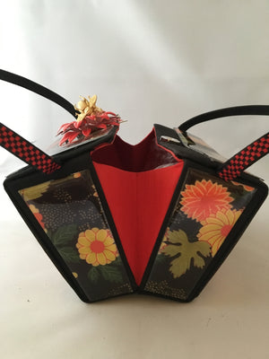 Vintage box purse with flowers and butterflies. From its cheeky checkerboard handle to its vintage enamel daisy with bouncy pouncy bee, this brilliant handbag will take you from spring through fall. Included are a matching purse for your little girl and her dolly, too!  Dimensions - Height 4.5"; Width 7"; Depth 4.5"; Handle 6"