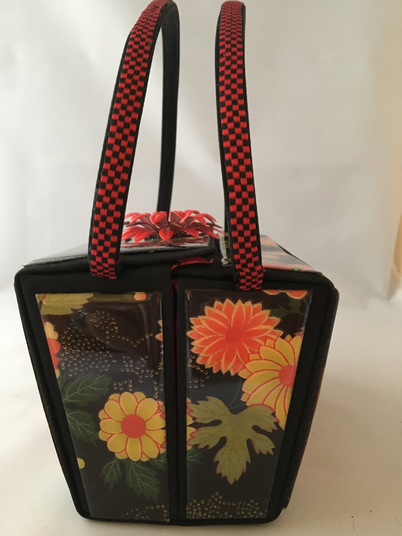 Vintage box purse with flowers and butterflies. From its cheeky checkerboard handle to its vintage enamel daisy with bouncy pouncy bee, this brilliant handbag will take you from spring through fall. Included are a matching purse for your little girl and her dolly, too!  Dimensions - Height 4.5"; Width 7"; Depth 4.5"; Handle 6"