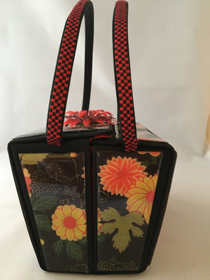 Vintage box purse with flowers and butterflies. From its cheeky checkerboard handle to its vintage enamel daisy with bouncy pouncy bee, this brilliant handbag will take you from spring through fall. Included are a matching purse for your little girl and her dolly, too!  Dimensions - Height 4.5"; Width 7"; Depth 4.5"; Handle 6"