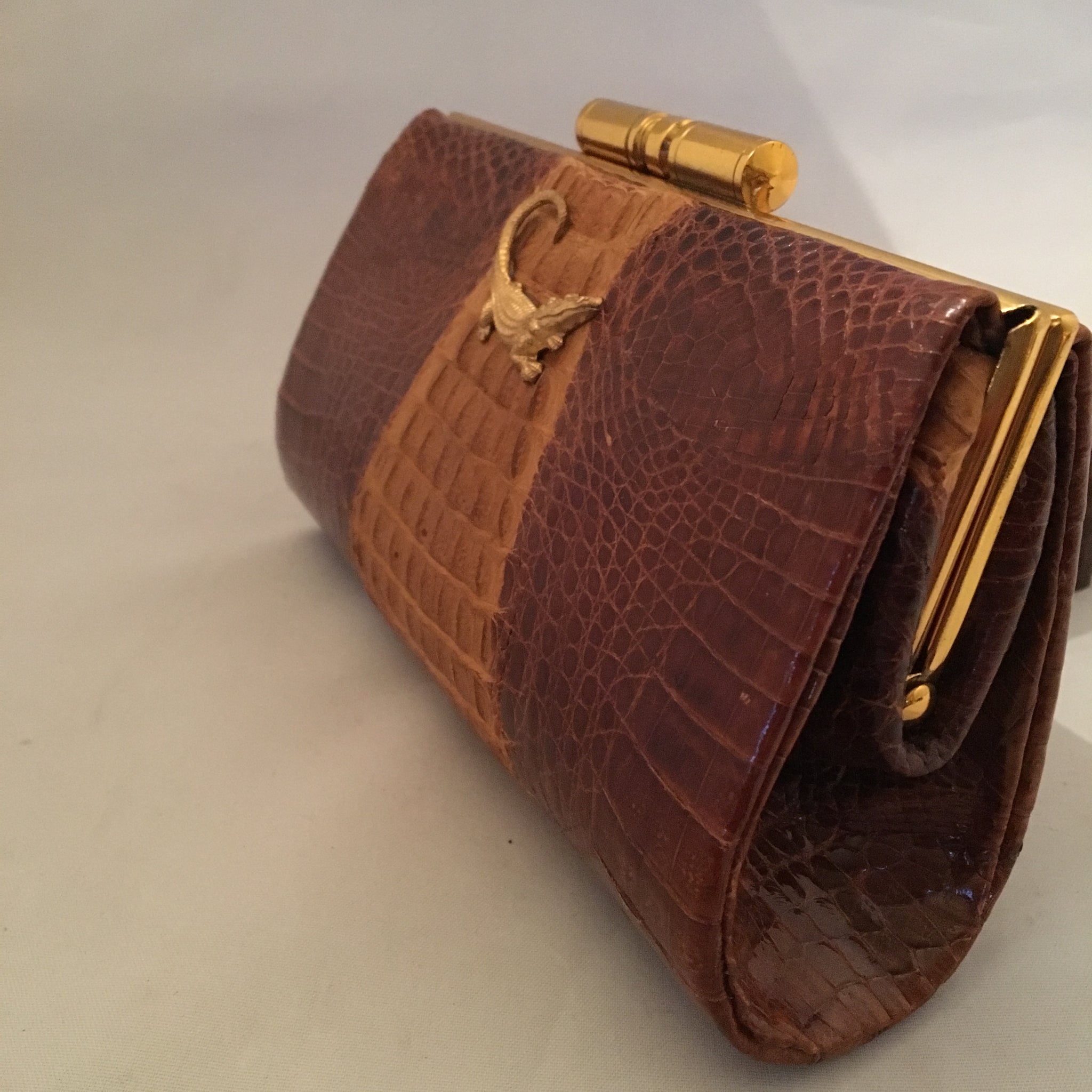 Vintage purse with two tones of caramel in baby crocodile leather, sturdy brass hardware and leather lining. Golden crocodile pendant on front. This baby will only get better as it grows older!  Dimensions - Height 5"; Width 7-1/2"; Depth 2-1/2" 