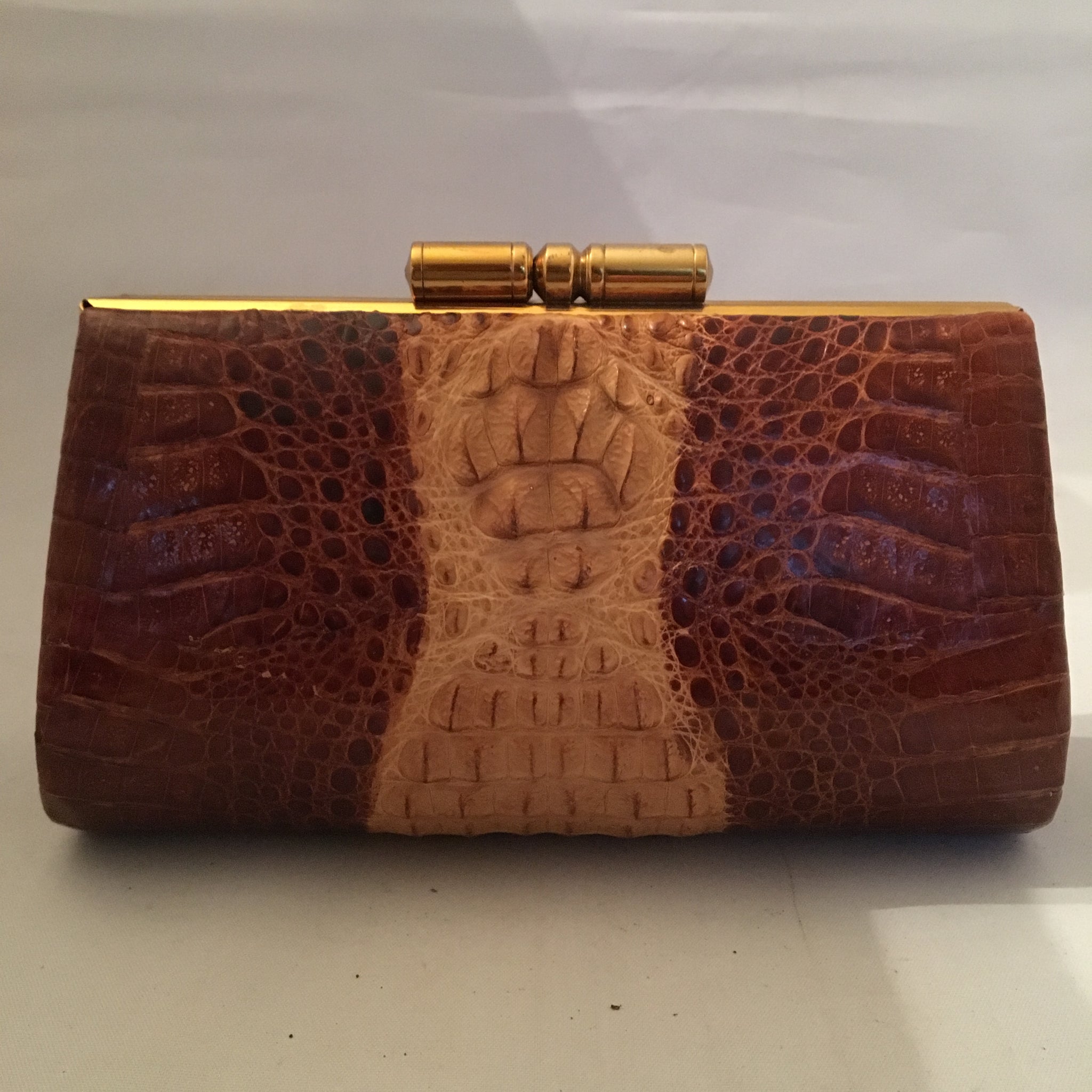 Vintage purse with two tones of caramel in baby crocodile leather, sturdy brass hardware and leather lining. Golden crocodile pendant on front. This baby will only get better as it grows older!  Dimensions - Height 5"; Width 7-1/2"; Depth 2-1/2" 