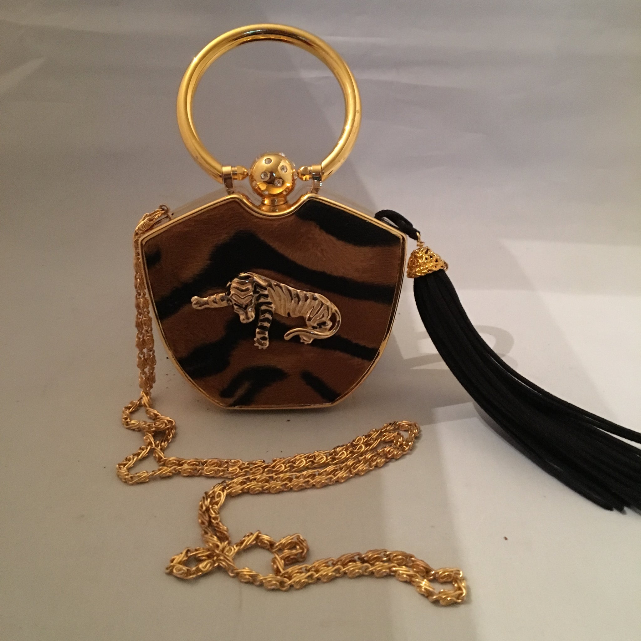 Darling yet daring, this vintage solid brass box purse roars attitude! Plush faux tiger pelt, golden tiger pendant, long black tassel, hideaway shoulder chain make it a conversation piece-de-resistance!