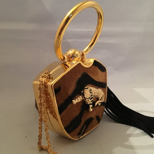 Darling yet daring, this vintage solid brass box purse roars attitude! Plush faux tiger pelt, golden tiger pendant, long black tassel, hideaway shoulder chain make it a conversation piece-de-resistance!