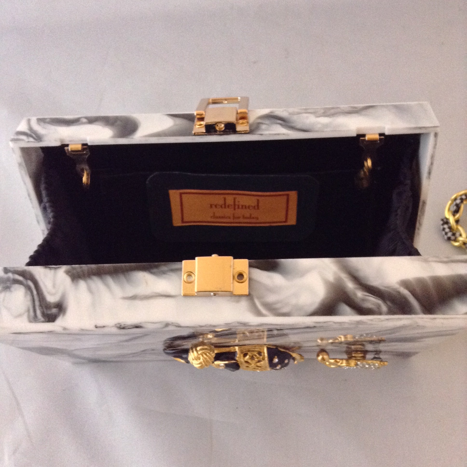 A fabulous box clutch or cross body bag with mama and baby enamel elephants, perfect for lunch to evening - or to a political rally! The hidden chain adds a whimsical touch of fun!