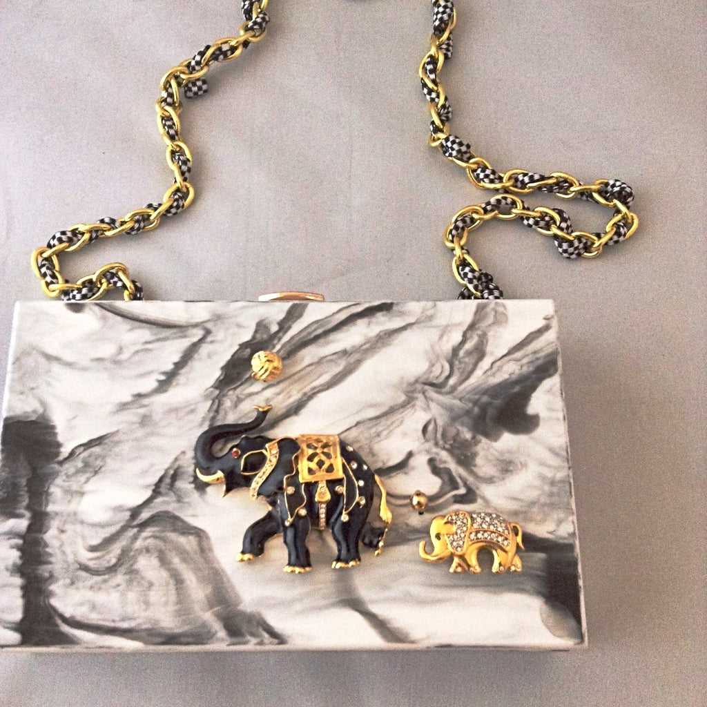 A fabulous box clutch or cross body bag with mama and baby enamel elephants, perfect for lunch to evening - or to a political rally! The hidden chain adds a whimsical touch of fun!
